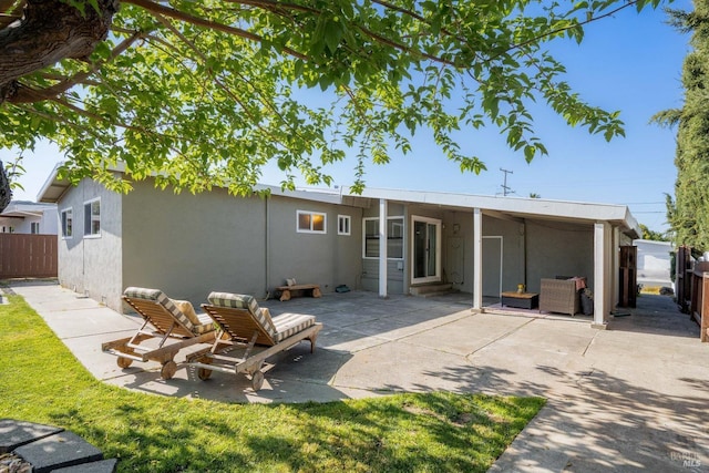 rear view of property featuring a patio area, a fenced backyard, and stucco siding