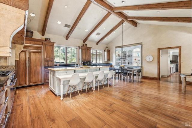 1571 Silver Trl, Napa, CA 94558 - kitchen featuring brown cabinets, a kitchen breakfast bar, a kitchen island with sink, and visible vents
