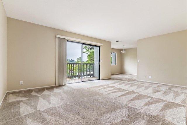empty room featuring light colored carpet and baseboards