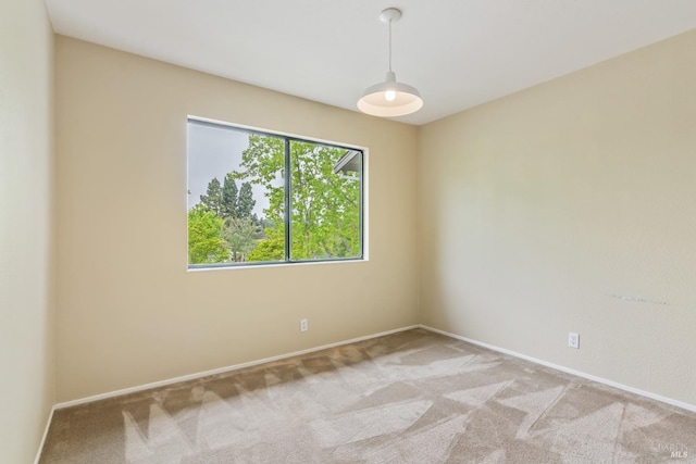 unfurnished room with light carpet and baseboards