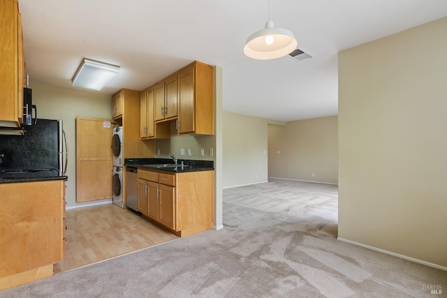kitchen featuring stainless steel dishwasher, light carpet, stacked washer and dryer, and a sink