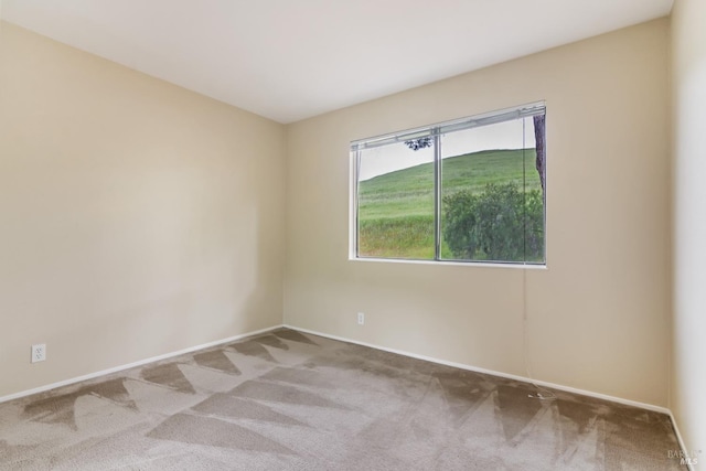 carpeted spare room with baseboards