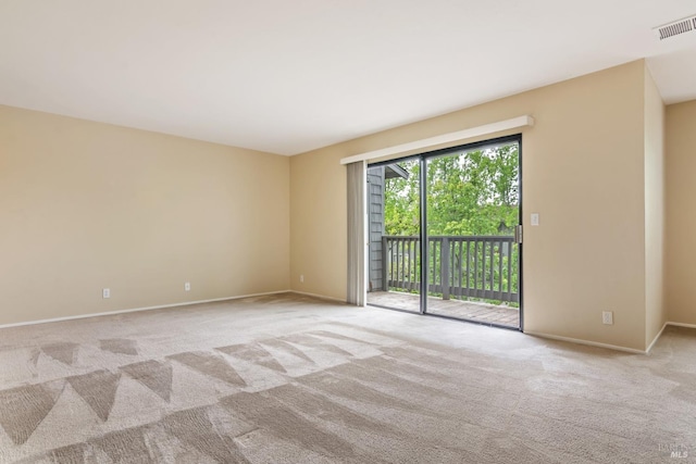carpeted empty room featuring baseboards and visible vents