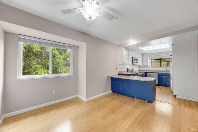 28 Acorn Cir, Petaluma, CA 94952 - kitchen with blue cabinets, appliances with stainless steel finishes, a peninsula, light countertops, and light wood-type flooring