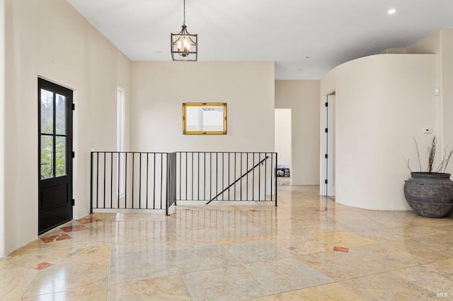 entryway featuring marble tiled floors and a chandelier