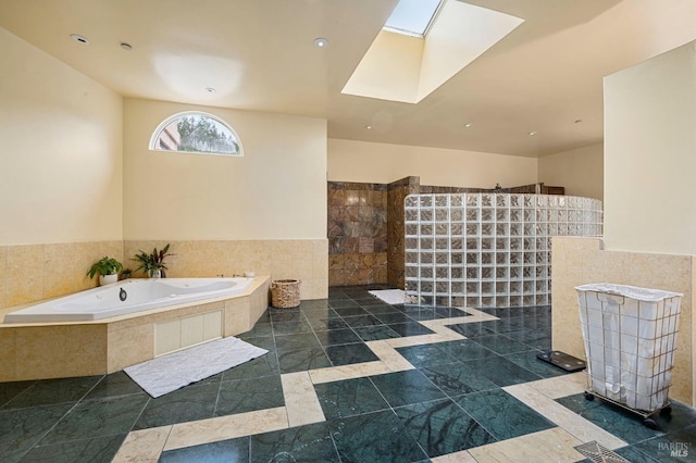bathroom with a garden tub, a skylight, a walk in shower, and recessed lighting
