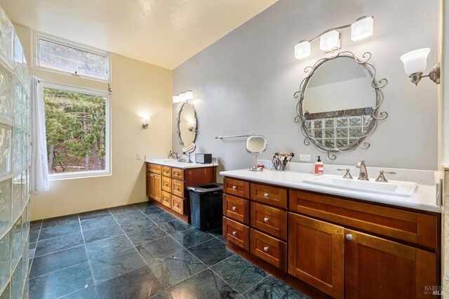 bathroom with two vanities and stone finish floors
