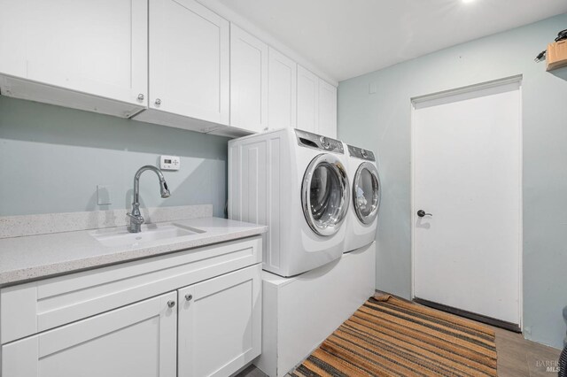 clothes washing area with cabinet space and separate washer and dryer