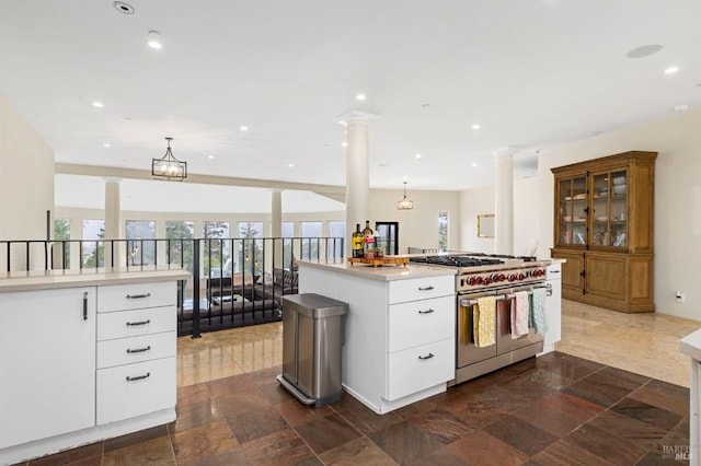 kitchen featuring stainless steel range, ornate columns, recessed lighting, light countertops, and hanging light fixtures