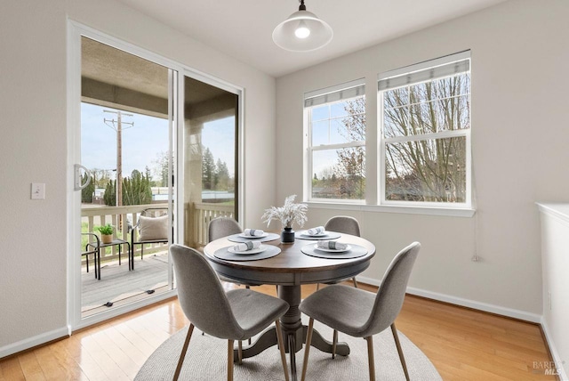 dining area featuring light wood-style floors and baseboards