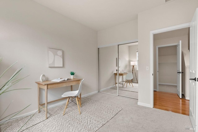 carpeted office space featuring baseboards