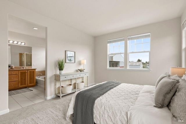 bedroom with light colored carpet, baseboards, connected bathroom, and light tile patterned floors
