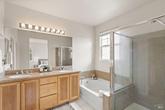 bathroom with a healthy amount of sunlight, a sink, tile patterned flooring, and a stall shower