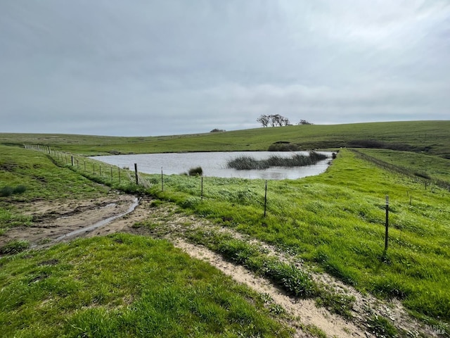 view of water feature featuring fence and a rural view