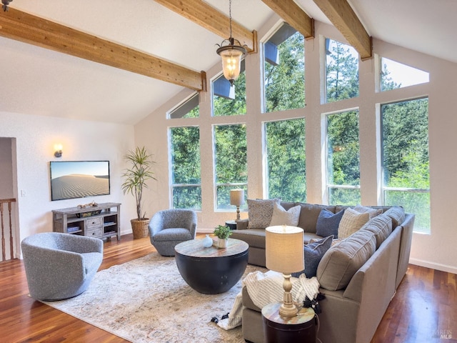 living area featuring vaulted ceiling with beams, baseboards, wood finished floors, and a healthy amount of sunlight
