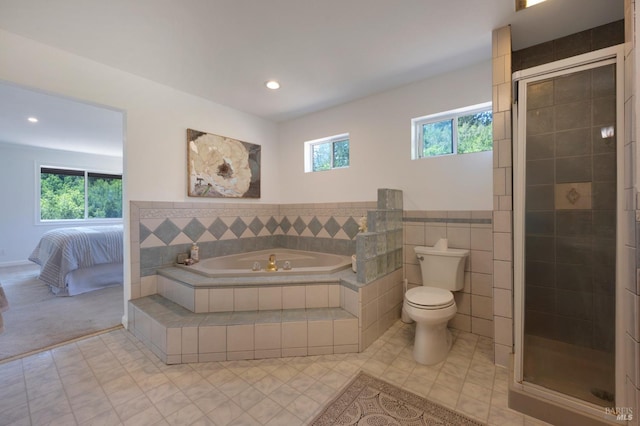 ensuite bathroom with toilet, recessed lighting, a shower stall, and a garden tub