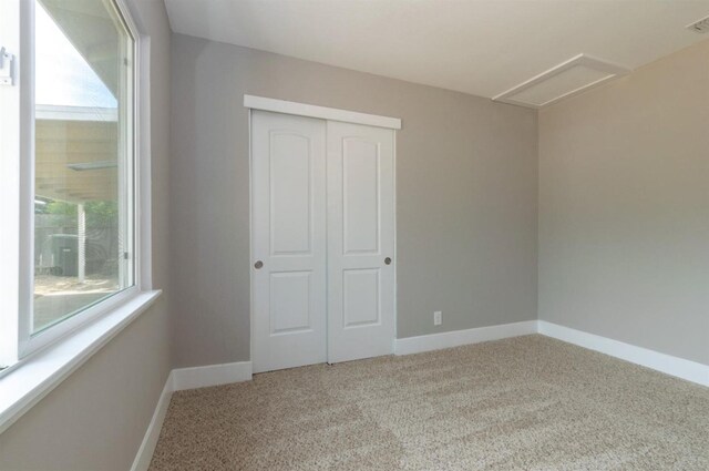 unfurnished bedroom featuring baseboards, carpet flooring, and a closet