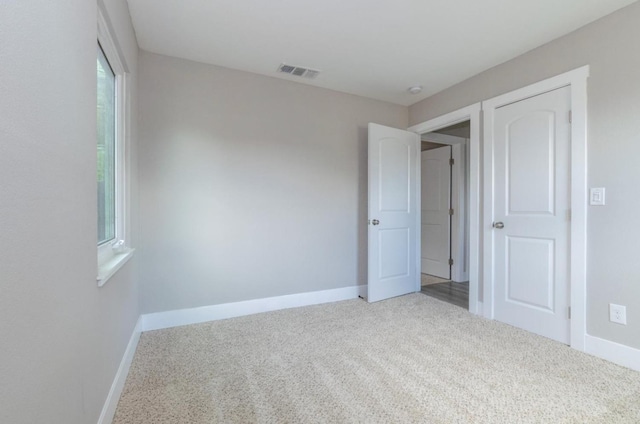 unfurnished bedroom with baseboards, visible vents, and carpet floors