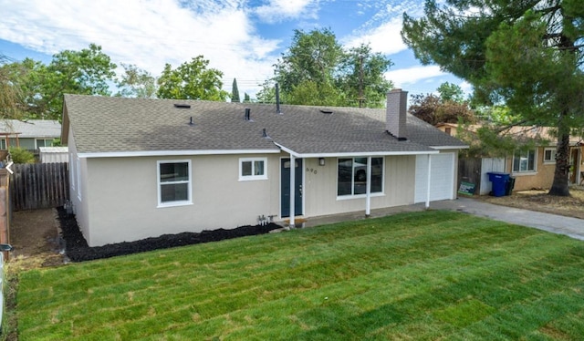 back of property featuring a chimney, fence, driveway, a lawn, and a garage