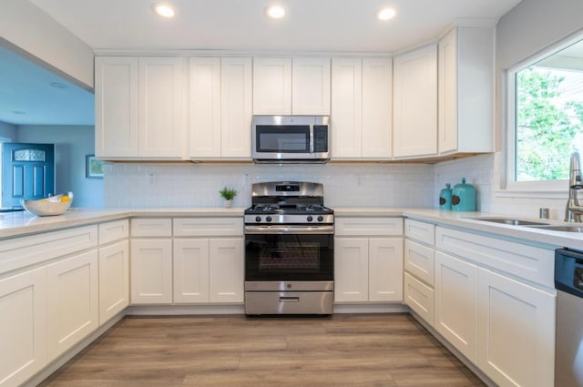 kitchen featuring a sink, light countertops, white cabinets, appliances with stainless steel finishes, and recessed lighting