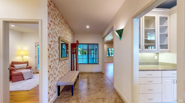 hall with wallpapered walls, baseboards, and recessed lighting