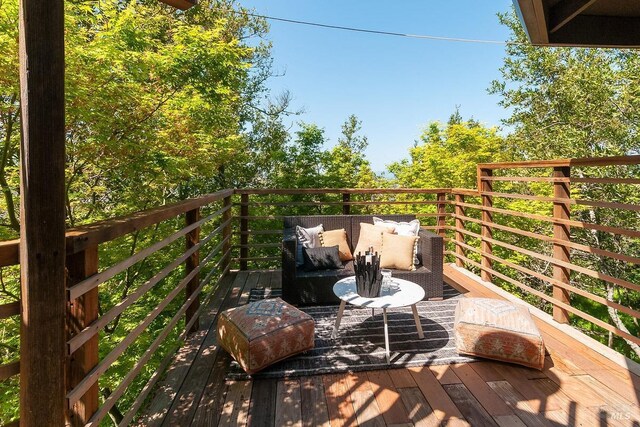 view of wooden balcony with an outdoor living space and a wooden deck