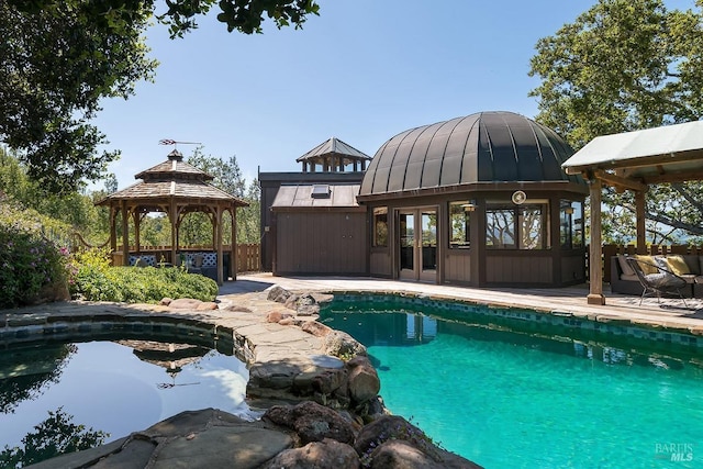 outdoor pool with an outdoor structure, a gazebo, a patio, and french doors