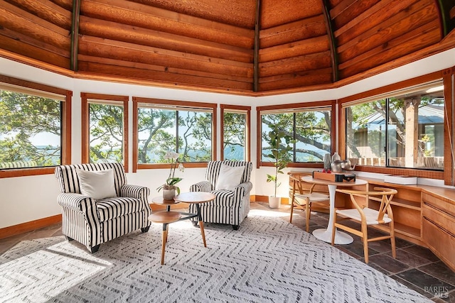 sunroom featuring a high ceiling and baseboards