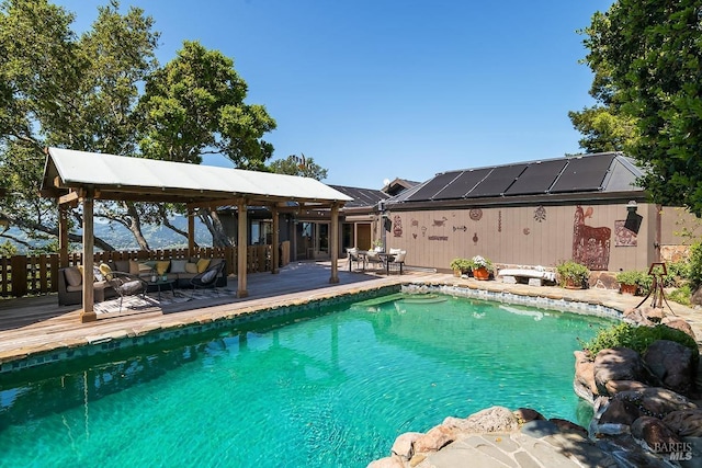view of swimming pool featuring an outdoor living space, a wooden deck, a fenced in pool, and a gazebo