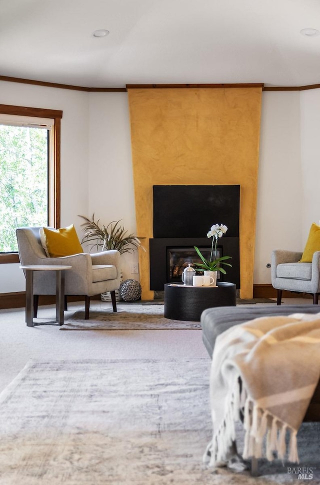 carpeted living room with a fireplace and crown molding