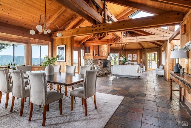 dining room with stone tile floors, plenty of natural light, vaulted ceiling with beams, and a mountain view