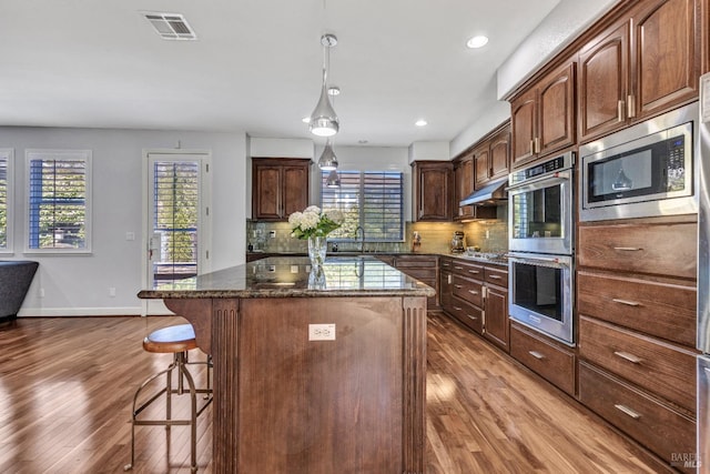 439 Mckenna Ct, Benicia, CA 94510 - kitchen featuring a kitchen bar, a center island, stainless steel appliances, and light wood-style flooring