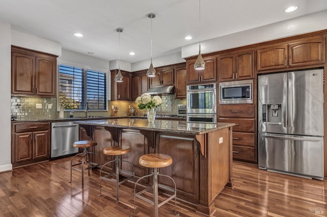 439 Mckenna Ct, Benicia, CA 94510 - kitchen featuring under cabinet range hood, dark wood-style flooring, a center island, and stainless steel appliances