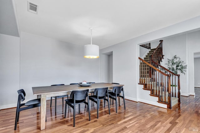 439 Mckenna Ct, Benicia, CA 94510 - dining space with baseboards, wood finished floors, visible vents, and stairs