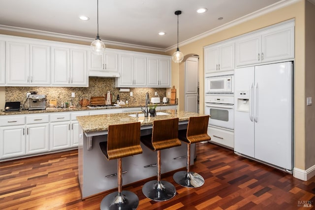 kitchen featuring a sink, white cabinetry, white appliances, under cabinet range hood, and ornamental molding