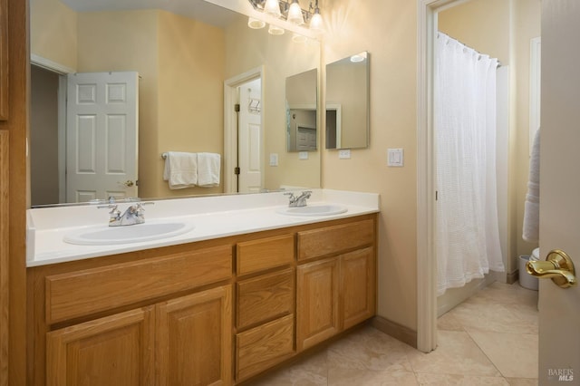 full bathroom featuring a shower with shower curtain, double vanity, tile patterned floors, and a sink