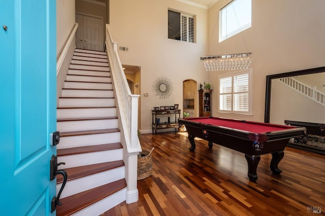 playroom with arched walkways, wood finished floors, visible vents, and a wealth of natural light