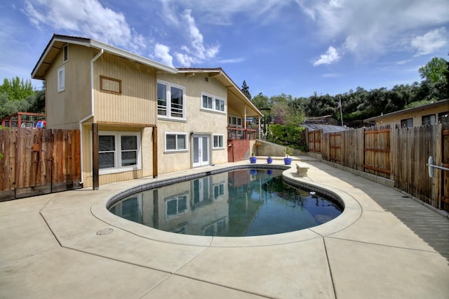 view of swimming pool featuring a patio, french doors, a fenced backyard, and a fenced in pool