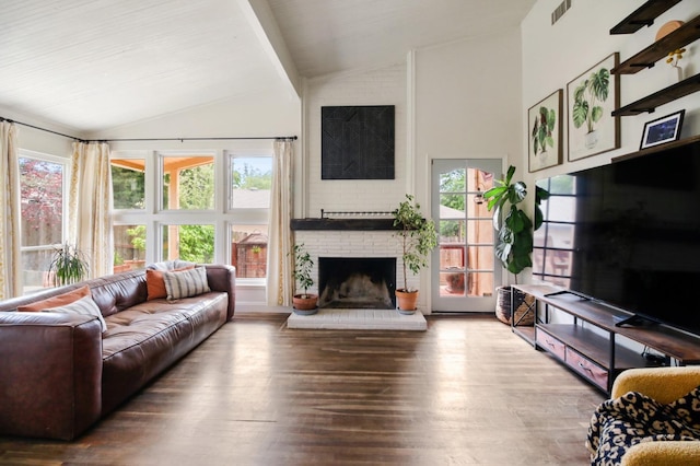 living area featuring visible vents, wood finished floors, a fireplace, and lofted ceiling