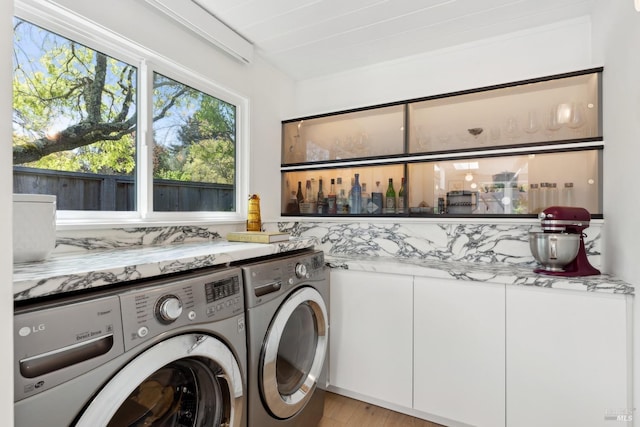 laundry room featuring washing machine and clothes dryer, light wood finished floors, and laundry area