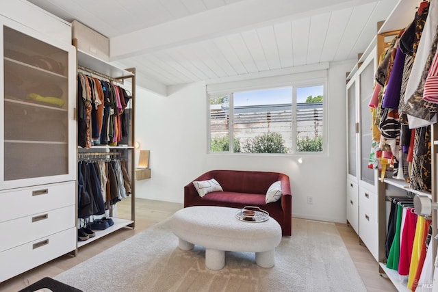 interior space with beamed ceiling, light wood-type flooring, a water view, and wood ceiling