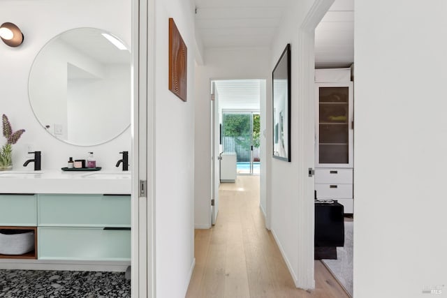 hall with a sink and light wood-style floors