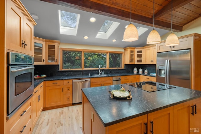 149 Auburn Way, Vacaville, CA 95688 - kitchen featuring vaulted ceiling with skylight, decorative backsplash, appliances with stainless steel finishes, a sink, and light wood-style floors