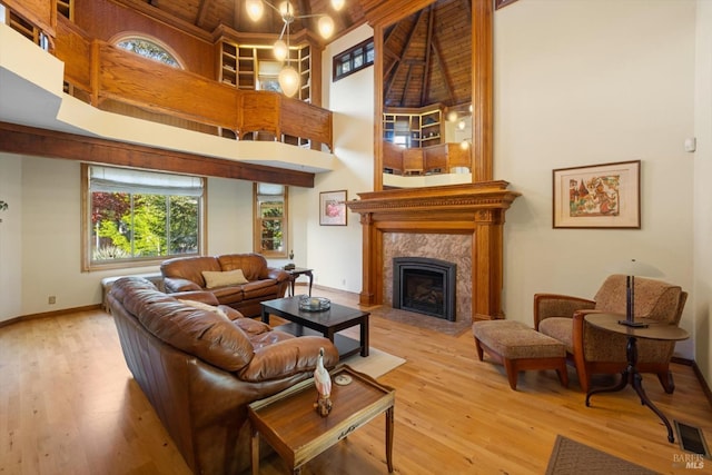 149 Auburn Way, Vacaville, CA 95688 - living area featuring a premium fireplace, baseboards, wood finished floors, a towering ceiling, and visible vents