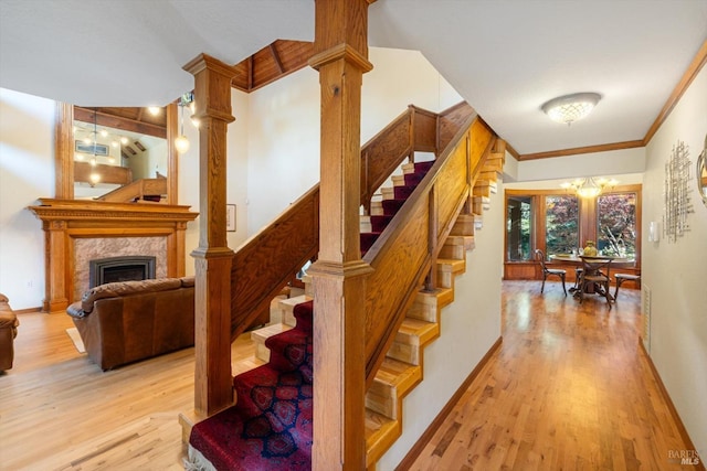 149 Auburn Way, Vacaville, CA 95688 - stairs featuring a fireplace, a chandelier, baseboards, wood finished floors, and ornamental molding