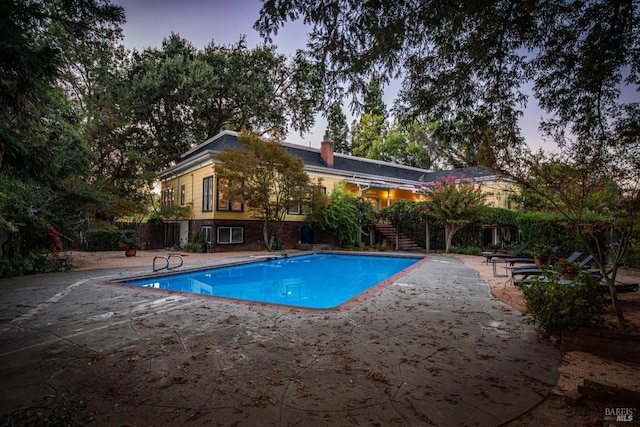 pool with stairway and a patio