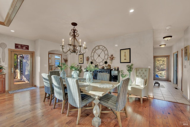dining space with recessed lighting, baseboards, an inviting chandelier, and light wood-style flooring