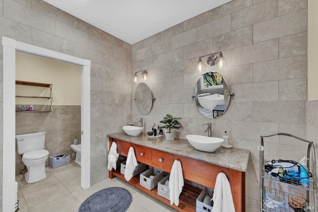 bathroom featuring toilet, tile patterned flooring, a sink, and tile walls
