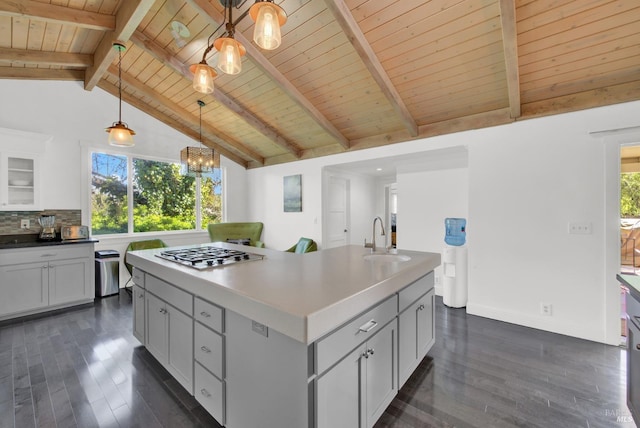 kitchen with stainless steel gas cooktop, wooden ceiling, an inviting chandelier, and a sink