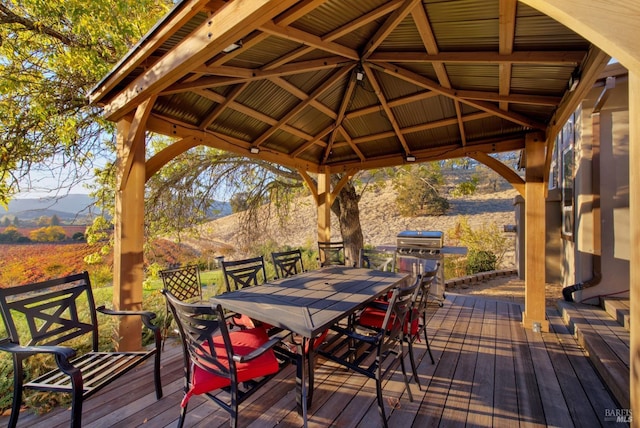 wooden terrace with area for grilling, outdoor dining area, a gazebo, and a mountain view